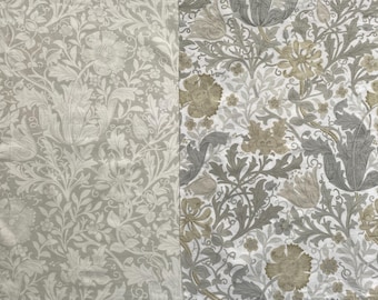 Pode incluir: Dois painéis de tecido com padrões florais. Um painel apresenta um fundo cinza claro com desenhos florais e de folhas brancas. O outro painel tem um fundo branco com desenhos florais e de folhas cinzentas e bege.