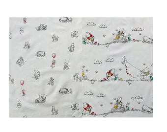 May include: White fabric with a repeating pattern of Winnie the Pooh and his friends. The characters are depicted in black and white with pops of red and yellow. The fabric features a whimsical woodland scene with clouds, bees, and a kite.