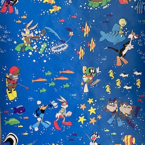 May include: A blue background featuring a variety of cartoon characters, including Bugs Bunny, Daffy Duck, Tweety Bird, and Sylvester the Cat. The characters are all wearing scuba gear and swimming in a sea of fish and bubbles.
