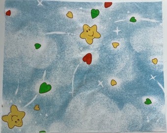 May include: Blue fabric with a white background featuring a repeating pattern of yellow stars with smiling faces, green and red hearts, and white stars.