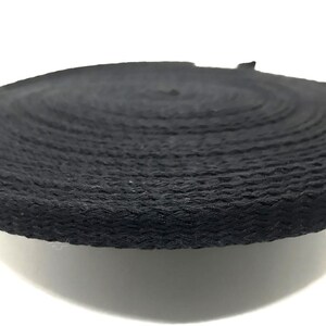 May include: A close-up of black cotton rope, showing the texture and detail of the braided cord.