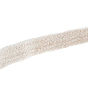 May include: A close-up of a white cotton twill tape. The tape has a woven texture and is ideal for crafting projects.
