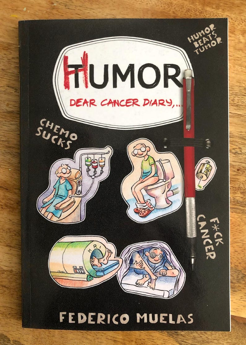 Op de afbeelding: Een zwart boek getiteld Humor Dear Cancer Diary door Federico Muelas met een bevestigd rood vulpotlood. De kaft bevat cartoonillustraties van medische behandelingen en de tekst Humor Beats Tumor, Chemo Sucks en Cancer F*ck.