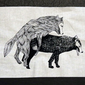 Könnte beinhalten: Schwarz-weiß-Illustration von zwei Wölfen, einer auf dem anderen, auf einem weißen Stoffhintergrund.