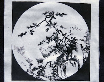 May include: Black and white image of a stylized tree with branches reaching up and out, set against a background of stylized mountains. The image is printed on a white fabric patch.