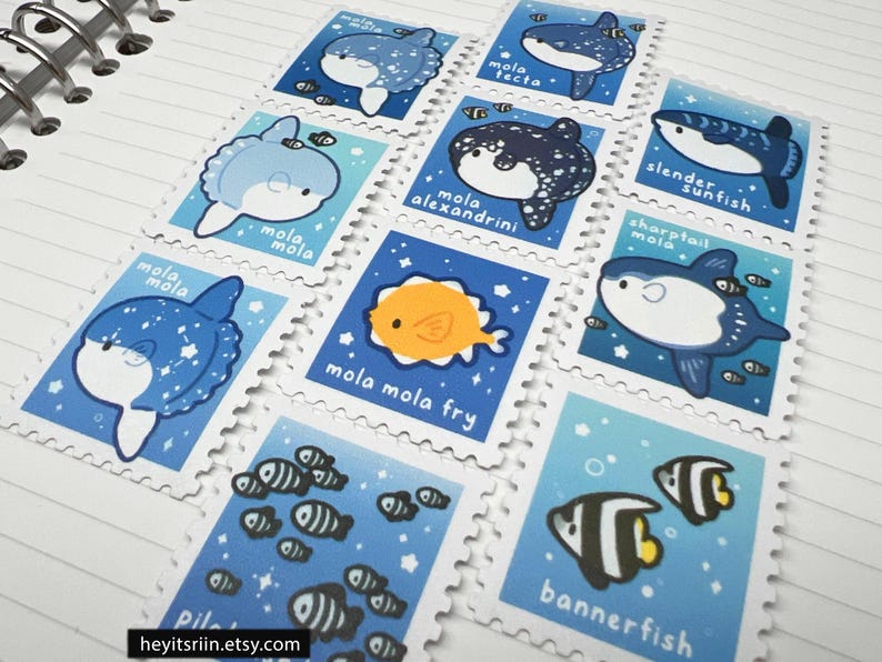 Peut inclure: Une collection de timbres illustr&eacute;s repr&eacute;sentant diverses cr&eacute;atures marines, dont des poissons-lunes et des poissons-drapeaux. Chaque timbre a un fond bleu avec des bordures blanches et les noms des poissons. Les timbres sont dispos&eacute;s sur une surface blanche lign&eacute;e.