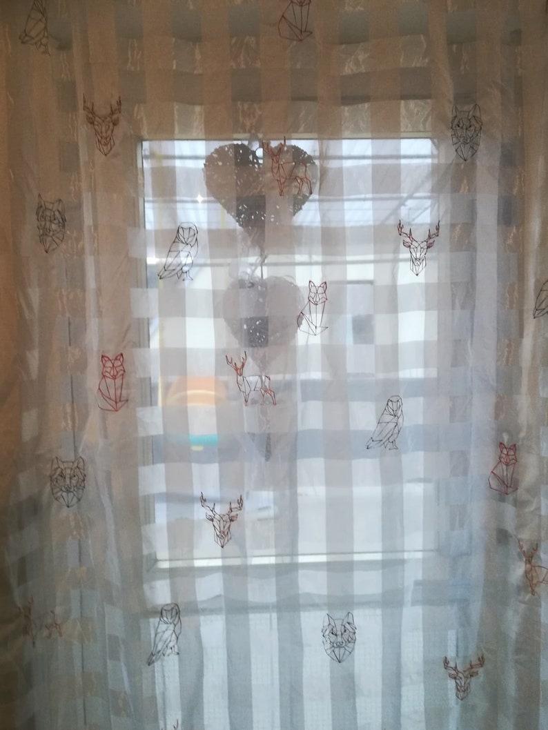 May include: White sheer curtains with a geometric pattern of animals, including owls, foxes, deer, and wolves. The animals are embroidered in a red and black thread.