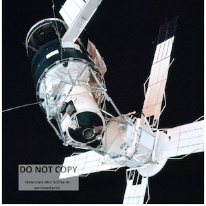 May include: A white space station with large solar panels in space. The station is in orbit around the Earth. The station is a complex structure with many different modules and components. The station is a symbol of human ingenuity and our ability to explore the universe.