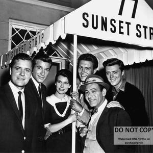 May include: Black and white photo of five men standing in front of a sign that reads "77 Sunset Strip".