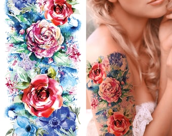 Puede incluir: Tatuaje temporal floral de acuarela con flores rojas, rosas y azules. El diseño del tatuaje presenta un ramo de rosas, anémonas y otras flores. El tatuaje está diseñado para ser aplicado en el brazo o el hombro.
