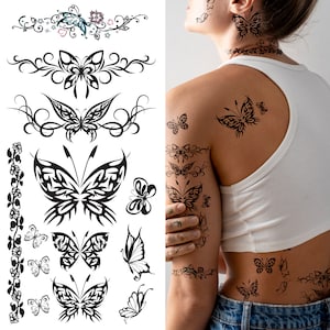 May include: A sheet of temporary tattoos featuring various butterfly designs. The tattoos are black and white and include intricate details. The sheet is shown on a person's arm and back.