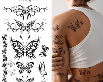 May include: A sheet of temporary tattoos featuring various butterfly designs. The tattoos are black and white and include intricate details. The sheet is shown on a person's arm and back.