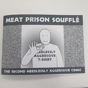 May include: A black and white comic book cover with the title "Meat Prison Souffle: The Second Needlessly Aggressive Comic". The cover features a cartoon character wearing a t-shirt that says "Needlessly Aggressive T-Shirt" and holding a mug that says "Needlessly Aggressive Mug".