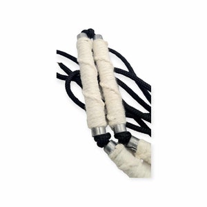 May include: Two white rope handles with black cords attached. The handles are wrapped in white rope and have silver metal ends.