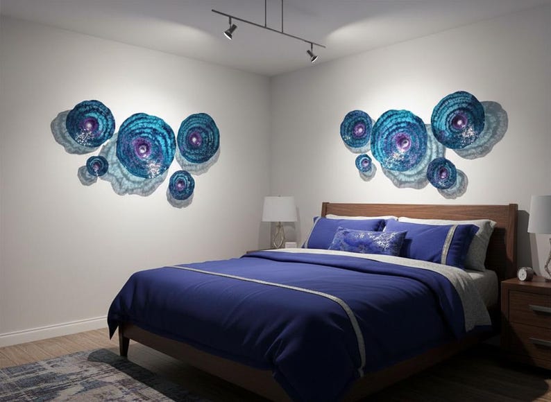 May include: Two sets of circular wall art pieces featuring concentric rings in shades of blue, teal, and purple. Each set consists of multiple discs of varying sizes arranged in a cluster, creating a textured, layered appearance on the wall.
