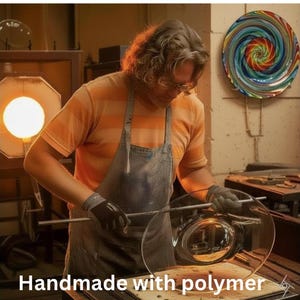 May include: A glassblower wearing a striped orange shirt and a grey apron works with a molten glass piece on a metal rod. The scene includes a glowing furnace, a colourful spiral glass wall art piece, and the text Handmade with polymer.