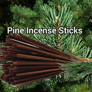 May include: A bundle of brown pine incense sticks, arranged in a fan shape, with the text "Pine Incense Sticks" printed in white on a green pine tree background.