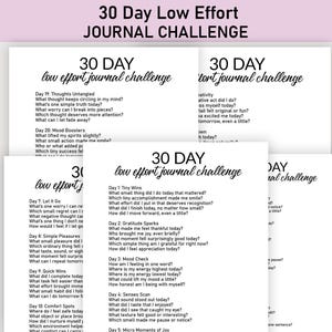 May include: A stack of white paper sheets with the text "30 Day Low Effort Journal Challenge" in a handwritten style. Each sheet contains prompts for daily journaling, encouraging self-reflection and mindfulness.