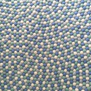 May include: A round rug made of felt balls in shades of blue, green, and white. The balls are arranged in a circular pattern, creating a unique and modern design.