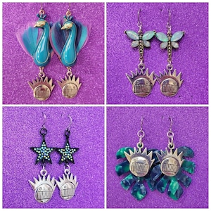 May include: Four pairs of earrings featuring different designs. The first pair features a peacock design with blue and green feathers. The second pair features a butterfly design with iridescent wings. The third pair features a star design with black and green accents. The fourth pair features a leaf design with green and silver accents.