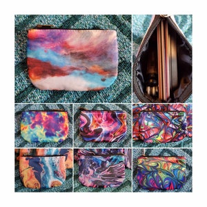 May include: Nine colorful zippered pouches with abstract designs. The pouches are made of fabric and have a zipper closure. The designs include swirls, tie-dye, and abstract patterns in shades of blue, pink, red, yellow, and green.