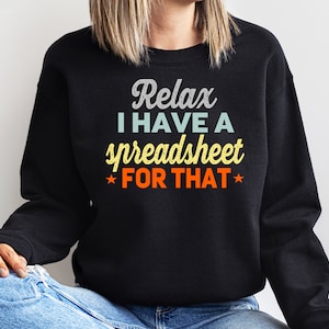 May include: Black sweatshirt with the text "Relax I have a spreadsheet FOR THAT" in a retro font. The text is in white, light blue, yellow, and orange. The sweatshirt is a casual style.