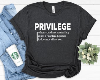 May include: A dark grey t-shirt with white text that reads "PRIVILEGE when you think something is not a problem because it does not affect you".