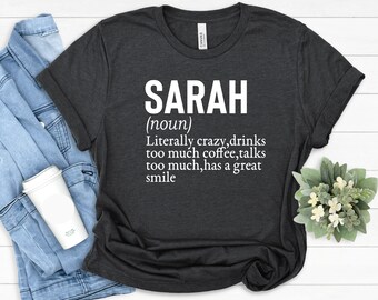 Può includere: Una maglietta grigio scuro con testo bianco che recita "SARAH (nome) Letteralmente pazza, beve troppo caffè, parla troppo, ha un grande sorriso."