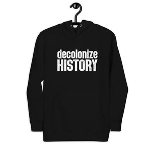 Pode incluir: Uma camisola com capuz preta que apresenta o texto branco "decolonize HISTORY" impresso no peito. A peça inclui um capuz com cordão, mangas compridas com punhos canelados e um bolso frontal tipo canguru, tudo em tecido preto.