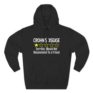 May include: Black hooded sweatshirt with a white graphic that says "Crohn's Disease" with a one-star rating and the text "Terrible, Would Not Recommend To a Friend."