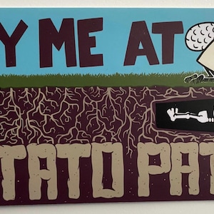 May include: A humorous illustration with the text "BURY ME AT THE POTATO PATCH." The image depicts a skeleton in a coffin, a person with angel wings, and a tombstone. The background is blue with green grass and brown roots.