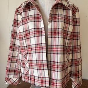 May include: A vintage plaid jacket in cream, red, and brown. The jacket features a full zipper, a collar, and two front pockets. The plaid pattern is a classic design, and the jacket is displayed on a mannequin.