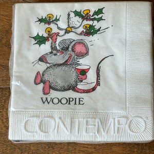 May include: A package of white paper napkins with a cartoon mouse holding a cocktail. The mouse is gray with pink ears and feet, and the word "WOOPIE" is printed below. The word "CONTEMPO" is embossed at the bottom.