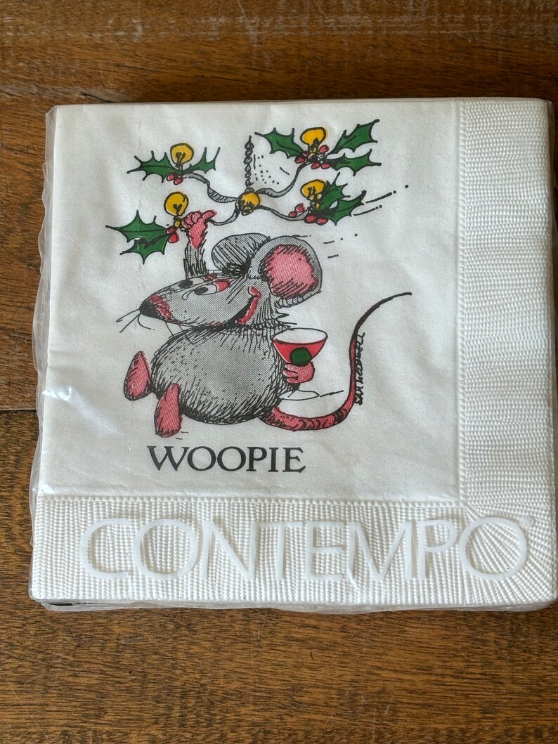 May include: A package of white paper napkins with a cartoon mouse holding a cocktail. The mouse is gray with pink ears and feet, and the word "WOOPIE" is printed below. The word "CONTEMPO" is embossed at the bottom.