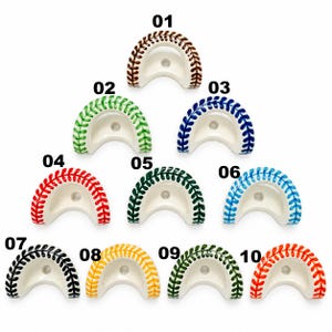 May include: Ten crescent-shaped ceramic holders arranged in a triangle, each featuring a hand-painted baseball-style stitch pattern in different colours: brown, light green, blue, red, dark green, light blue, black, yellow, forest green, and orange.