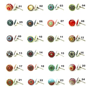May include: A collection of 24 decorative cabinet knobs with various colorful patterns. Each knob features a unique design, including floral, geometric, and abstract motifs, with a silver-tone metal base. The knobs are numbered 01 through 24.