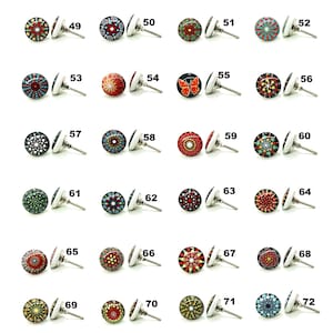 Op de afbeelding: Een verzameling decoratieve kastknoppen met diverse kleurrijke, patroonontwerpen. Elke knop heeft een ronde, patroonvormige voorkant met een zilverkleurige metalen basis en een schroef voor bevestiging. De knoppen hebben een verscheidenheid aan kleuren en patronen.