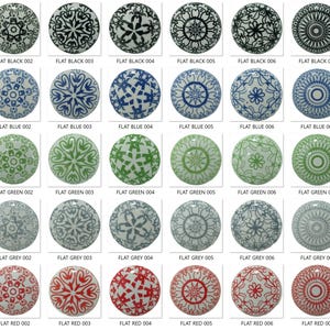 May include: A collection of decorative cabinet knobs with various patterns and colors. The knobs are round and feature designs in black, blue, green, gray, and red. Each knob is labeled with a number.