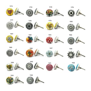 May include: A selection of decorative cabinet knobs with diverse designs. The knobs display colourful patterns, including floral, tree, and geometric motifs. Each knob has a white base and a silver-toned stem. The image includes the numbers 173 to 194.