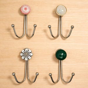 May include: A white ceramic mug with a black handle and the text "But First, Coffee" in a black, handwritten-style font. The mug is on a white surface.