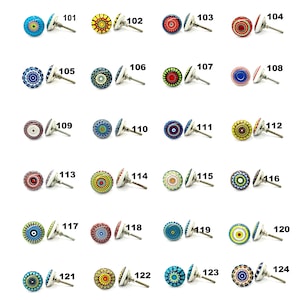 Op de afbeelding: Een verzameling decoratieve keramische kastknoppen met diverse kleurrijke mandala-ontwerpen. Elke knop heeft een zilverkleurige metalen basis en een schroef voor eenvoudige installatie. De knoppen zijn genummerd van 101 tot 124.