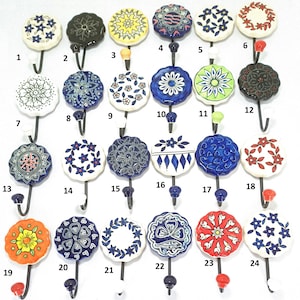May include: A selection of decorative ceramic wall hooks with floral and geometric patterns. Each hook has a unique colour scheme, including blue, white, yellow, and red, with a dark metal hook.