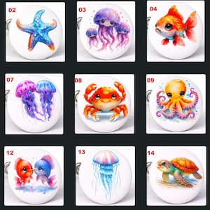 May include: A set of fifteen white, round decorative knobs, each with a different watercolour illustration of sea creatures. Designs include an octopus, starfish, jellyfish, fish, and crab. Each knob has a metal loop for attachment.