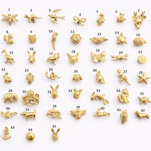 以下が含まれることがあります： さまざまな動物やオブジェクトの形をした、小さな金色の金属チャームのコレクション。チャームには、トンボ、鹿の頭、蝶、タツノオトシゴ、リス、イカリが含まれています。