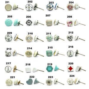 May include: A selection of decorative cabinet knobs in diverse designs. Styles include floral, geometric, and clock faces. Colours range from cream, blue, and pink to green and gold. Each knob has a metal stem for installation.