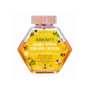 May include: A hexagonal glass bottle of organic African raw honey infusion with a wooden cap. The label reads "Immunity" and lists adaptogens and antioxidants. The bottle contains 380 ml of honey and is made in England.