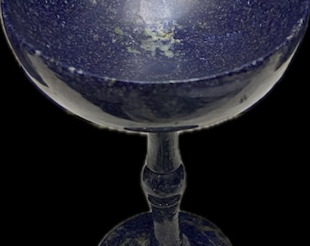 May include: A blue, hand-carved, lapis lazuli goblet with a wide bowl and a tall, slender stem. The goblet has a speckled, marbled appearance.