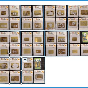 Pode incluir: Uma coleção de modelos de corte Sizzix com vários designs, incluindo palavras, formas e temas de feriados. Os modelos são exibidos em sua embalagem original, com o logotipo Sizzix visível.