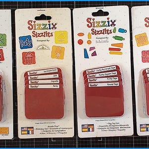 Könnte beinhalten: Vier Sizzix Sizzlits Stanzformen-Sets auf weißen Trägerkarten. Die Sets enthalten verschiedene Formen und Designs, wie z. B. Käfer, Elemente zum Thema Party und Blumen. Jedes Set hat eine rote Kunststoffhülle.