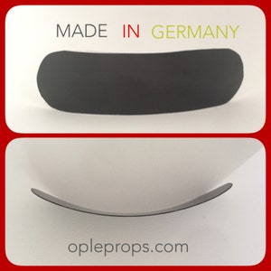 May include: A curved, black prop with a matte finish. The prop is arched and has rounded edges. The text "MADE IN GERMANY" is printed above the prop. The website "opleprops.com" is printed below the prop.